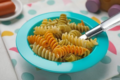 Photo of Bowl with tasty fusilli pasta on white table, closeup