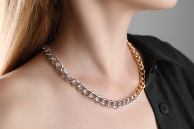 Photo of Woman wearing metal chain, closeup. Luxury jewelry