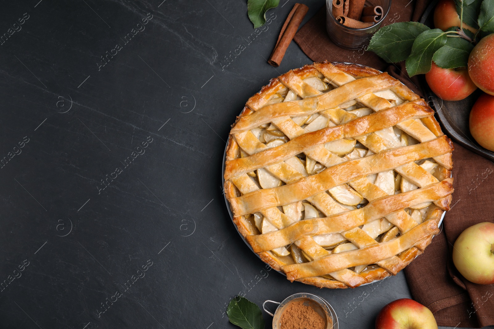Photo of Delicious traditional apple pie on black table, flat lay. Space for text