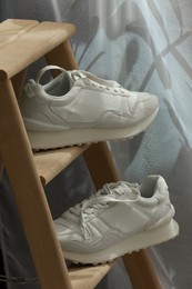 Photo of Stylish presentation of trendy sneakers on wooden ladder