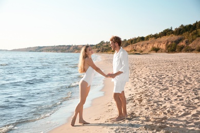 Photo of Romantic young couple spending time together on beach