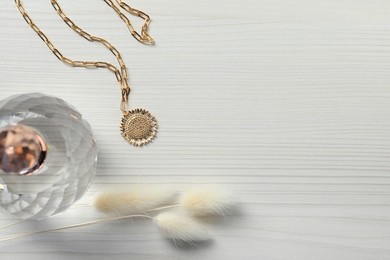 Photo of Necklace, bottle of perfume and dry plants on white wooden table, flat lay. Space for text