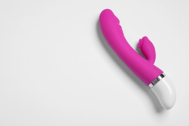 Photo of Purple vibrator on white background, top view. Sex toy