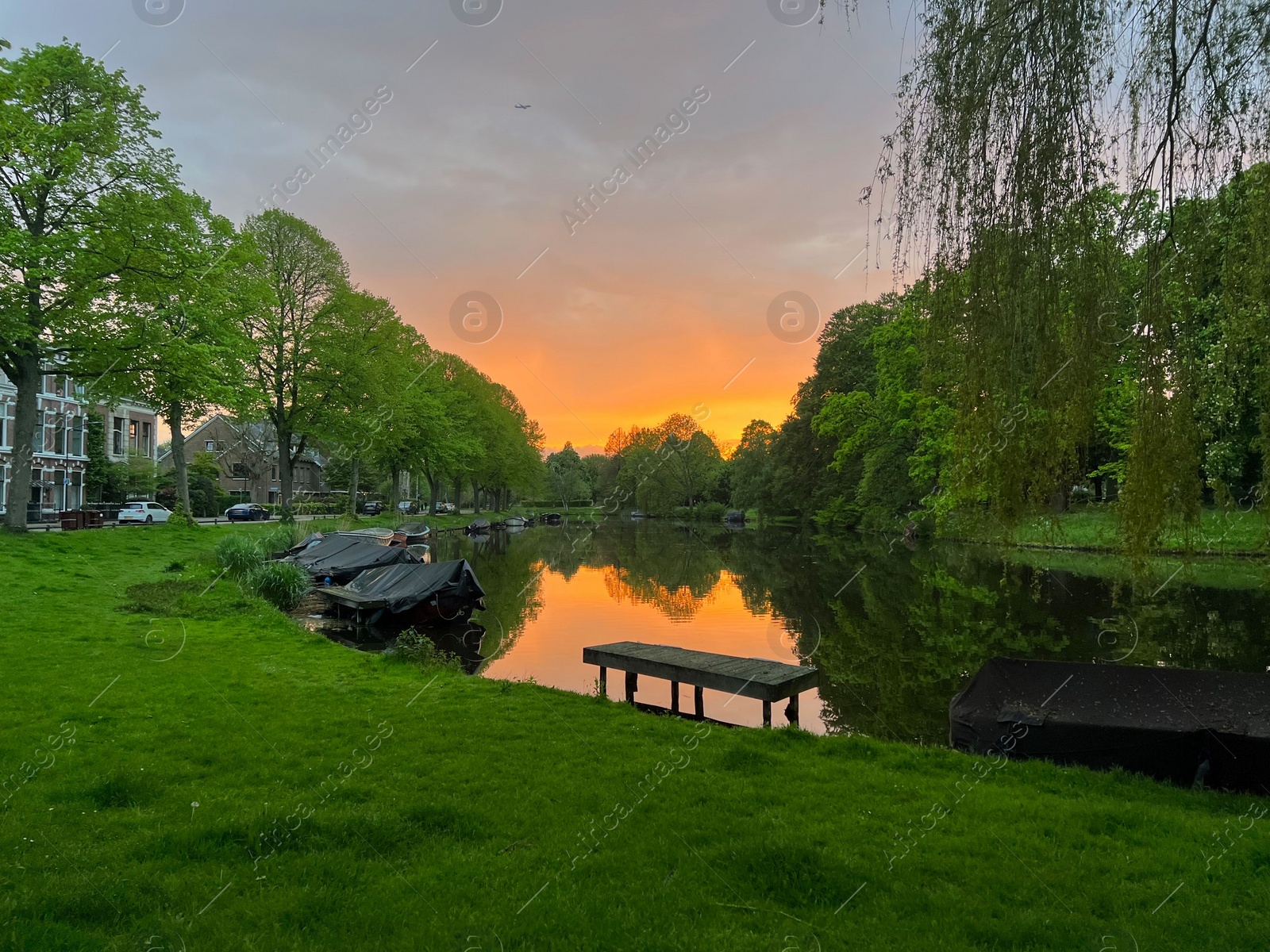 Photo of Scenic view of canal with moored boats at sunset