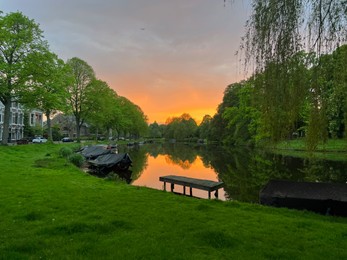 Photo of Scenic view of canal with moored boats at sunset