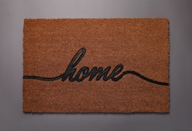 Doormat with word Home on grey background, top view