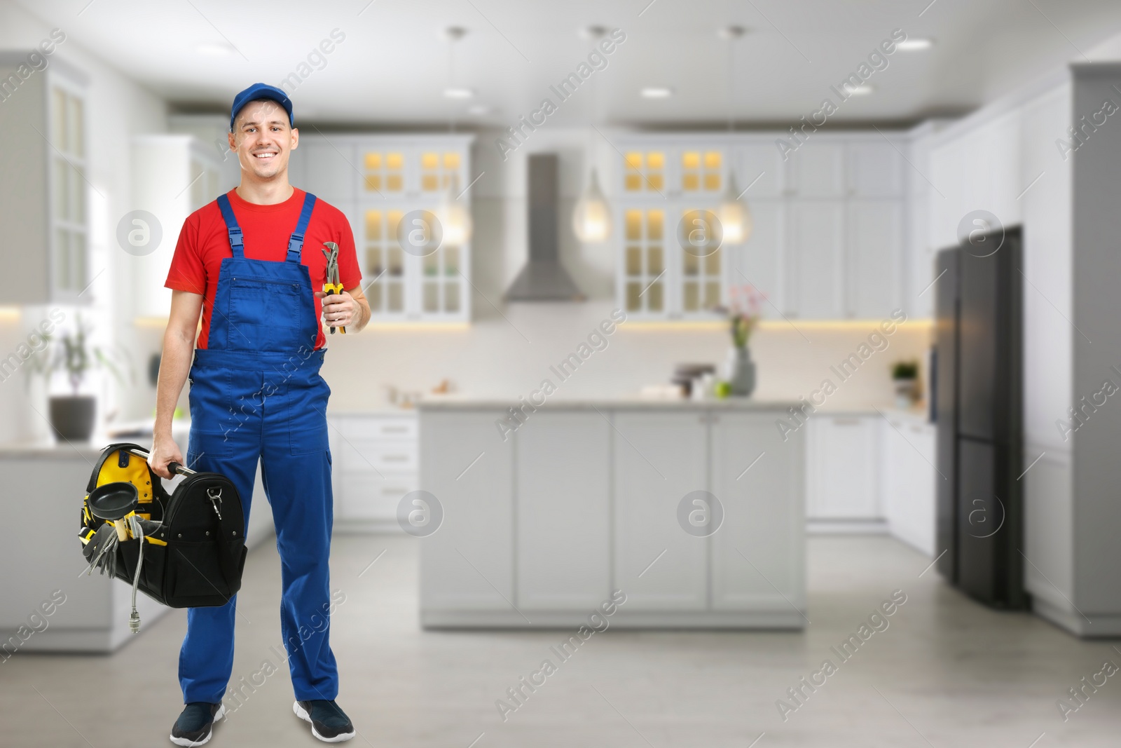 Image of Young plumber with tool bag in kitchen, space for text