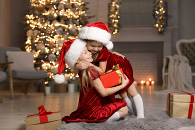Photo of Cute little children with Christmas gift at home