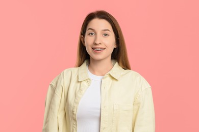 Photo of Portrait of smiling woman with dental braces on pink background