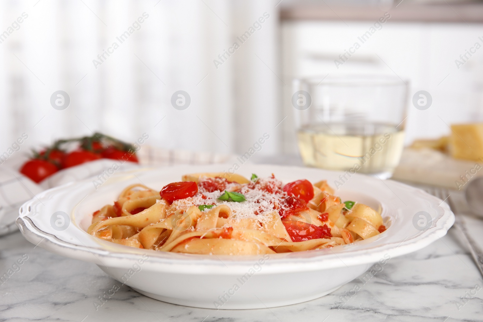 Photo of Tasty pasta with tomatoes, cheese and basil on white marble table