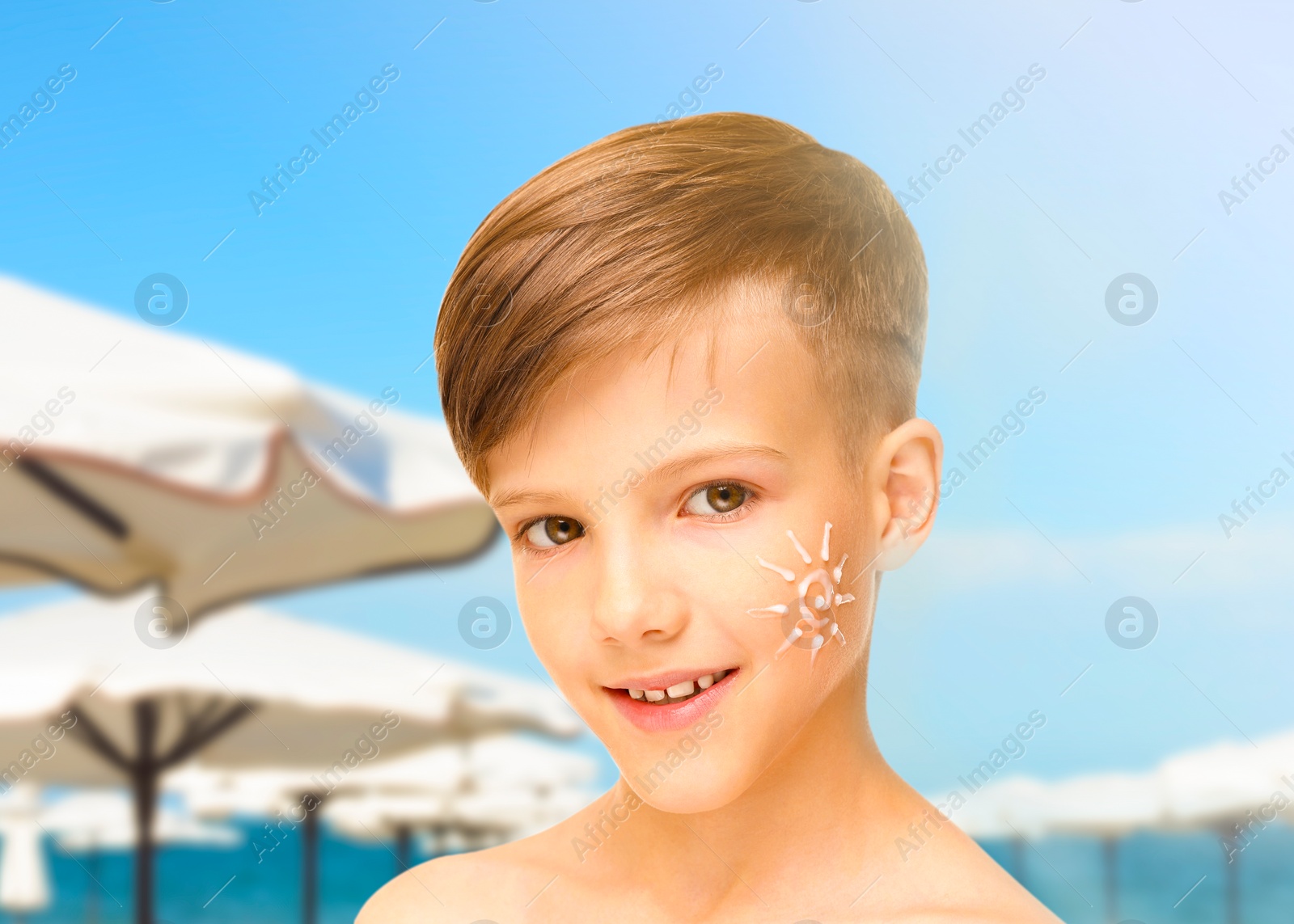 Image of Sun protection. Boy with sunblock on his face on beach