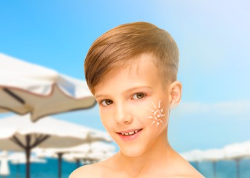 Sun protection. Boy with sunblock on his face on beach
