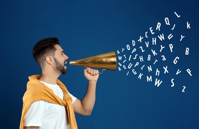 Image of Young man with megaphone and letters flying out of it on blue background