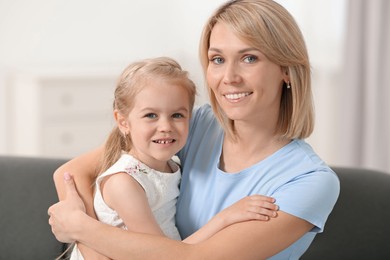 Photo of Happy mother and daughter on sofa at home