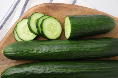 Photo of Fresh whole and cut cucumbers on table, top view