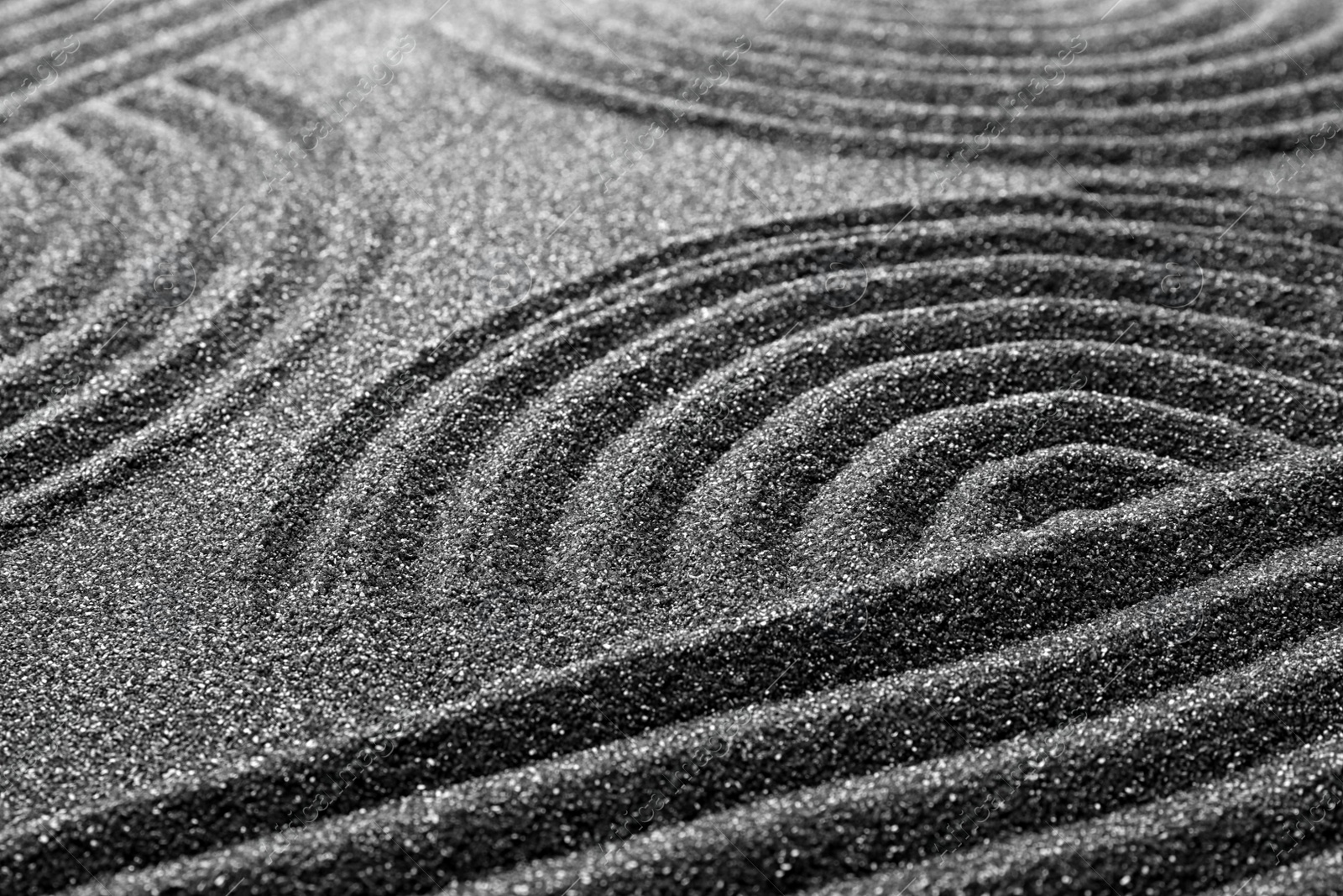 Photo of Pattern on decorative black sand, closeup. Zen and harmony