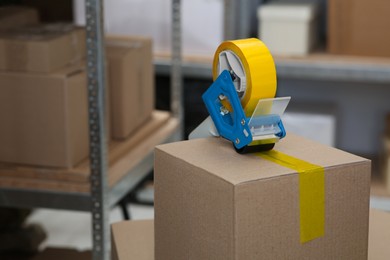 Photo of Taping box with adhesive tape dispenser indoors. Space for text