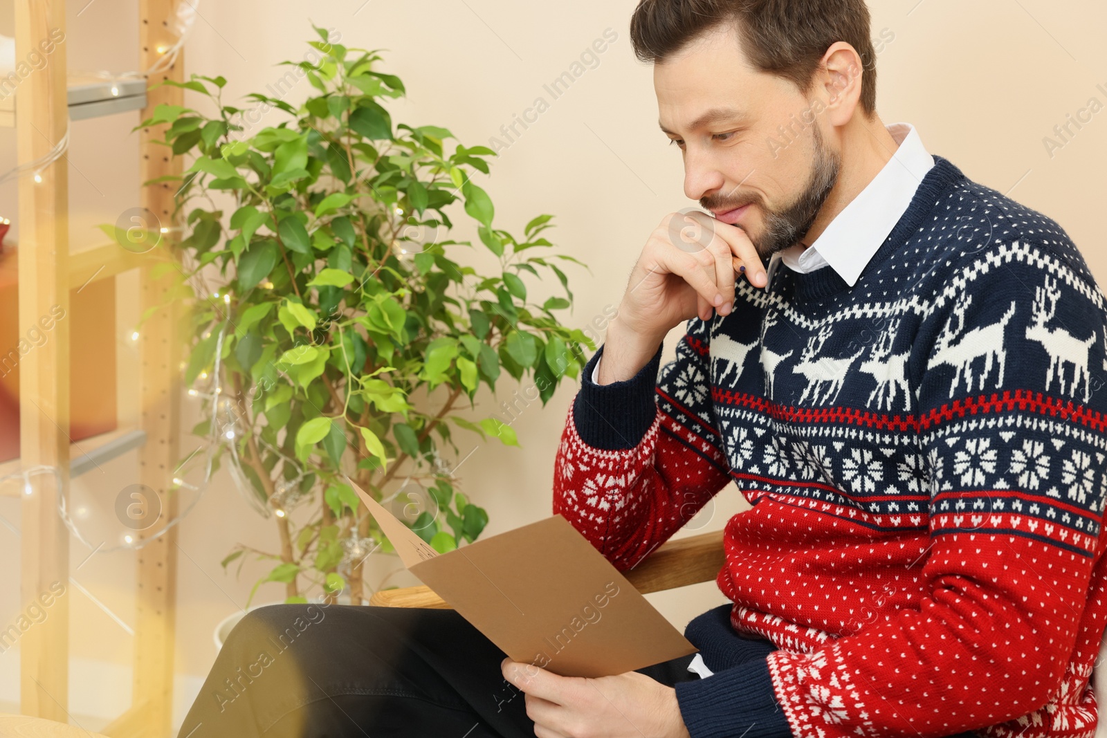 Photo of Man reading greeting card in living room