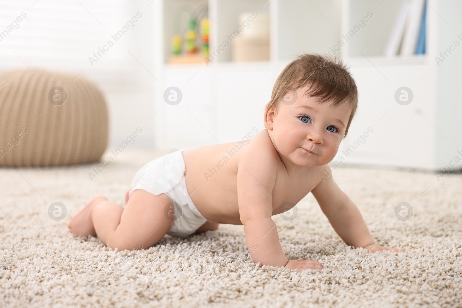 Photo of Cute baby boy crawling on carpet at home