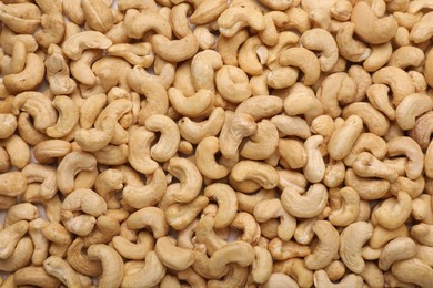 Many tasty cashew nuts as background, top view