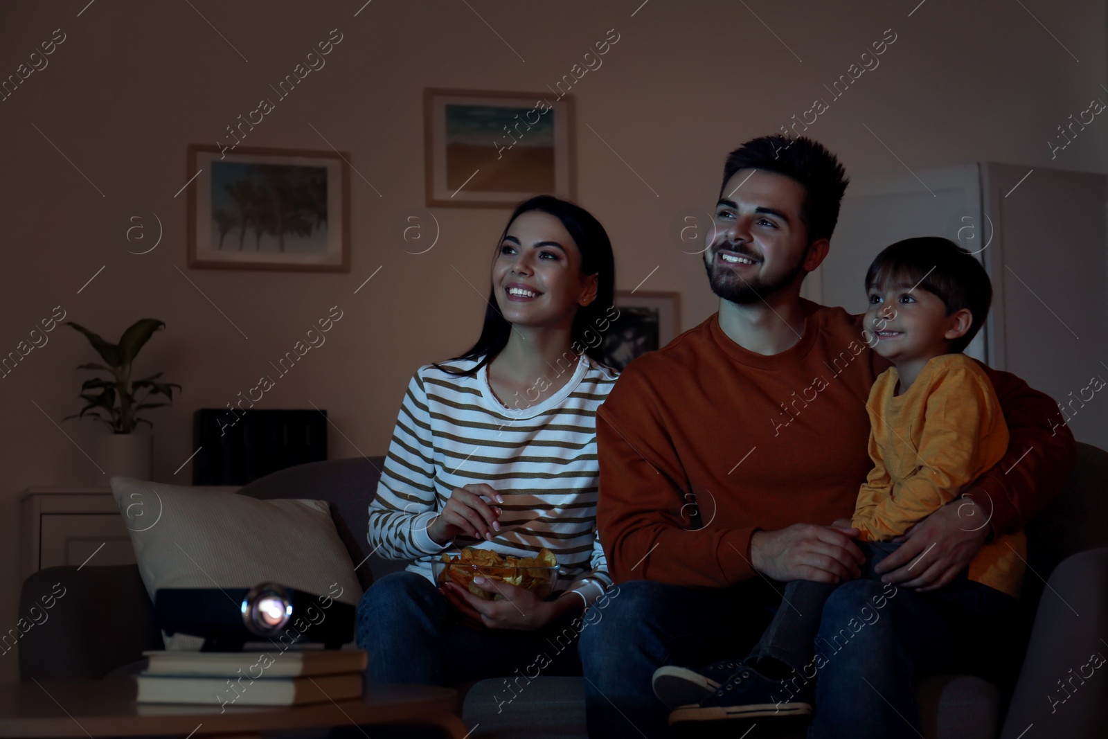 Photo of Family watching movie using video projector at home