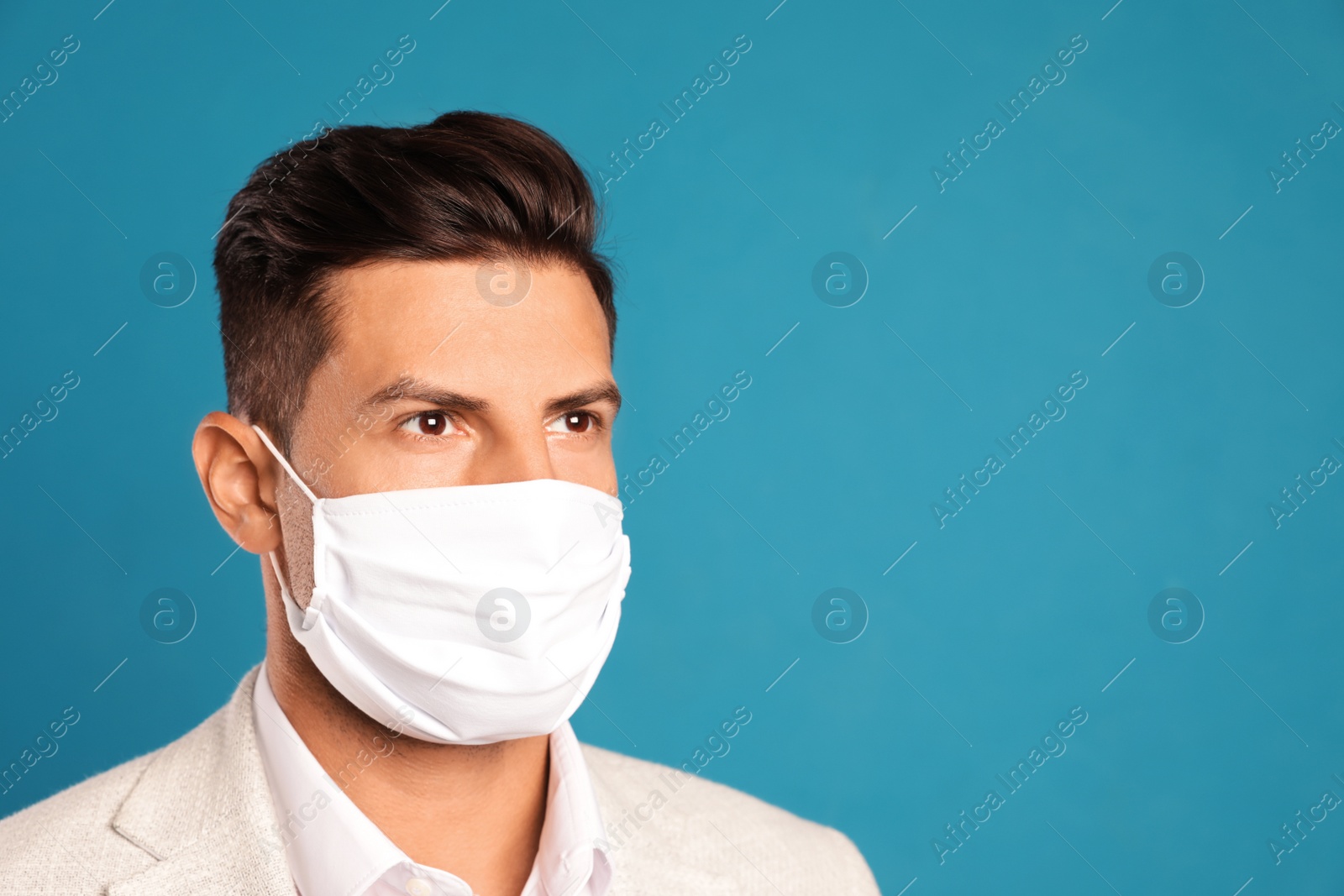 Photo of Man in protective face mask on blue background. Space for text