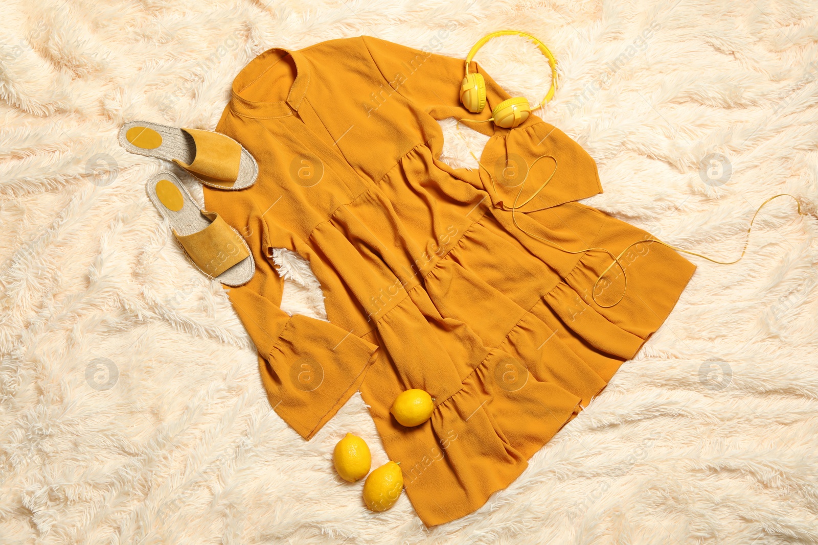 Photo of Flat lay composition with stylish yellow dress on beige blanket