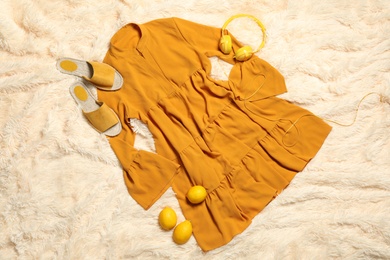 Photo of Flat lay composition with stylish yellow dress on beige blanket