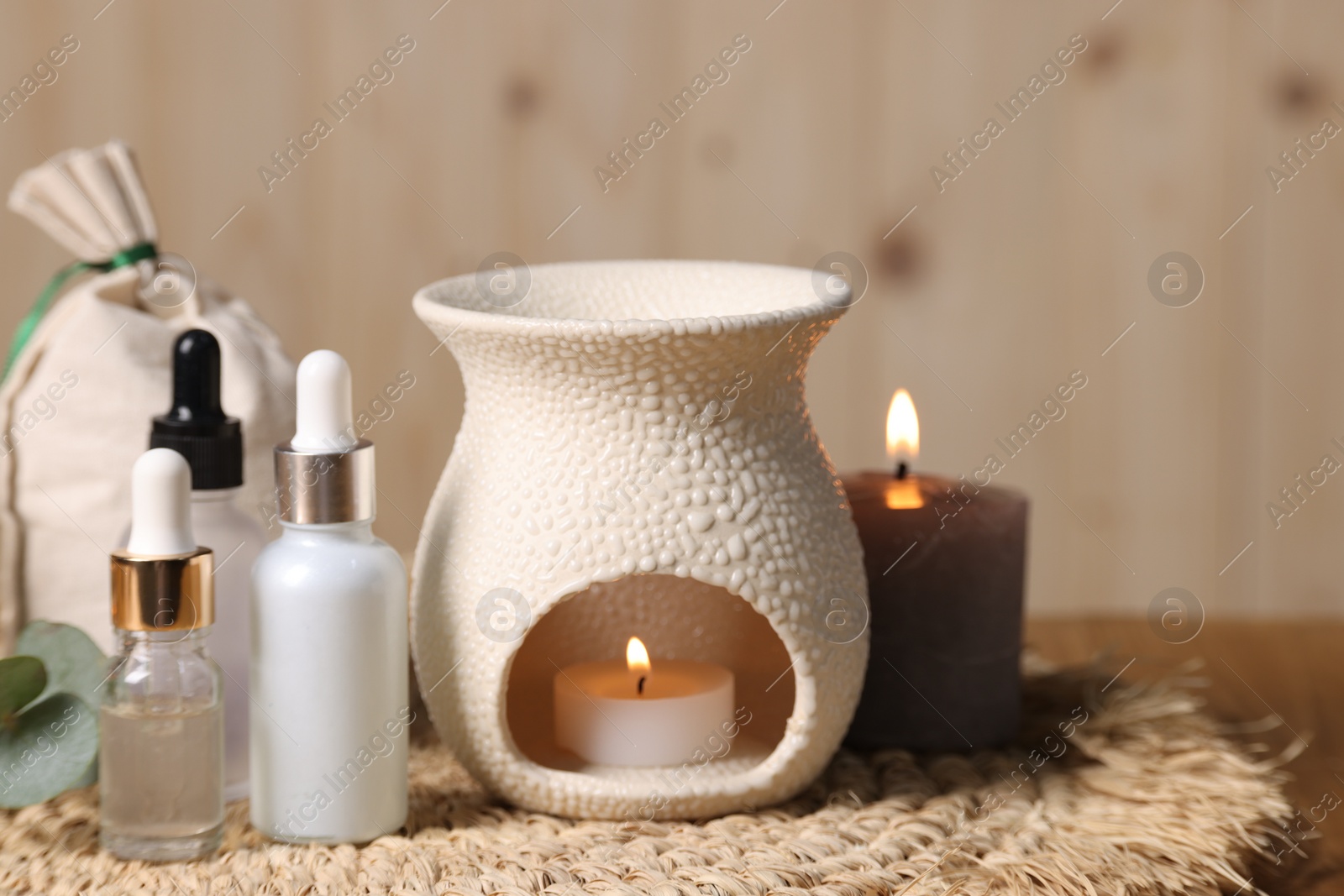 Photo of Different aromatherapy products and burning candles on table, closeup