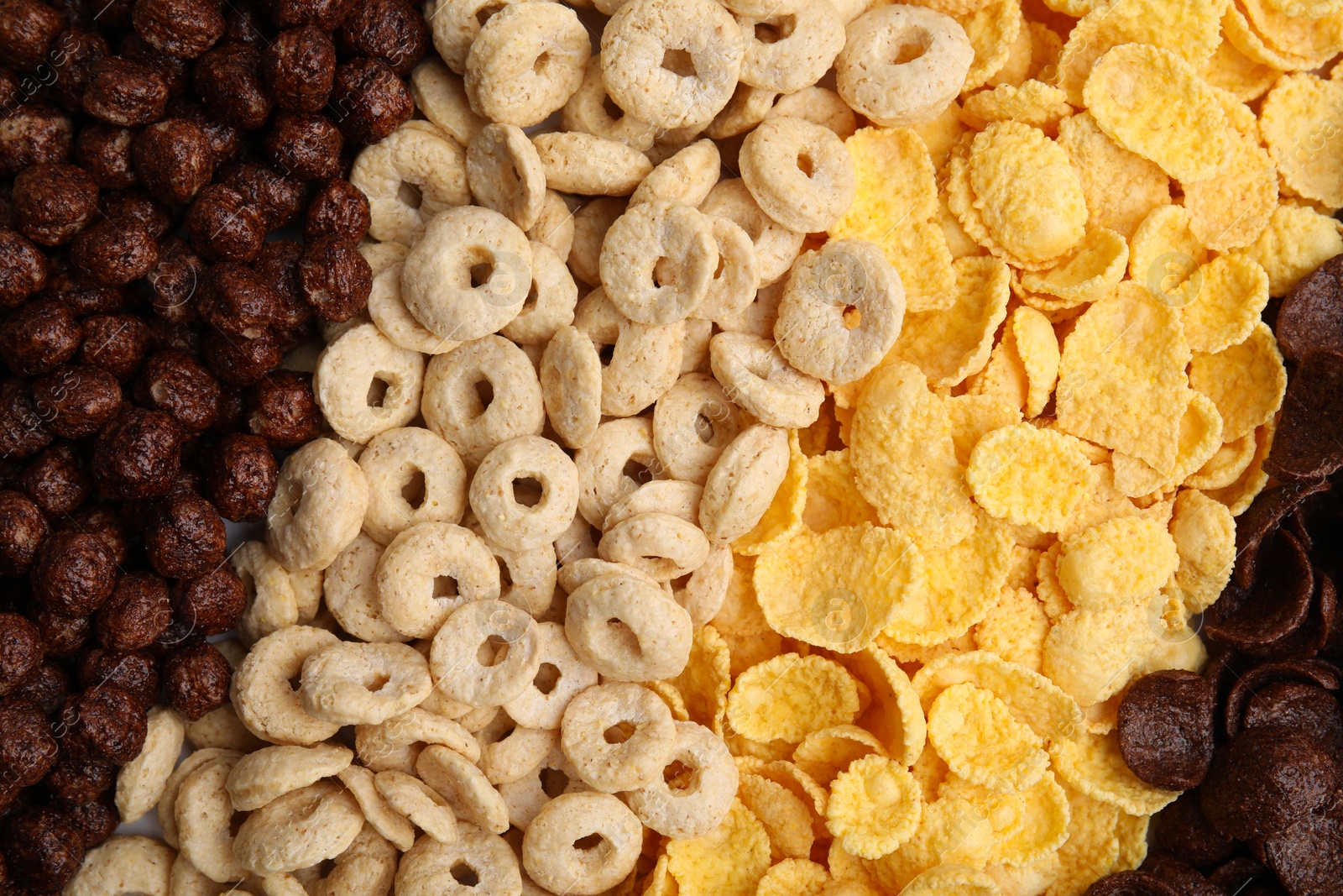 Photo of Different types of breakfast cereals as background, top view