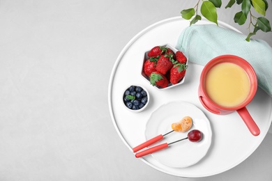 Photo of Table with chocolate fondue on grey floor, top view. Space for text