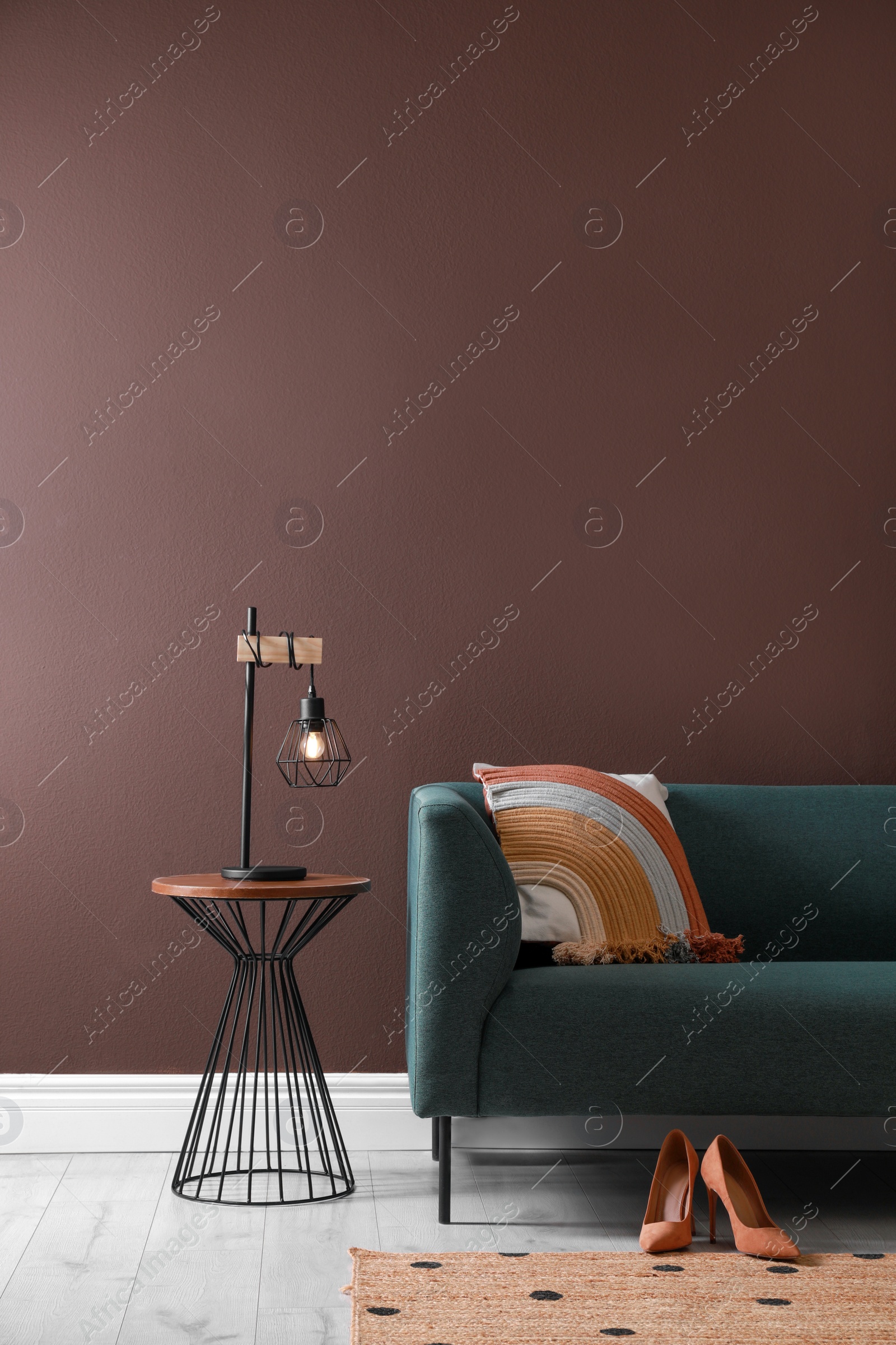 Photo of Stylish living room interior with comfortable sofa and lamp on coffee table