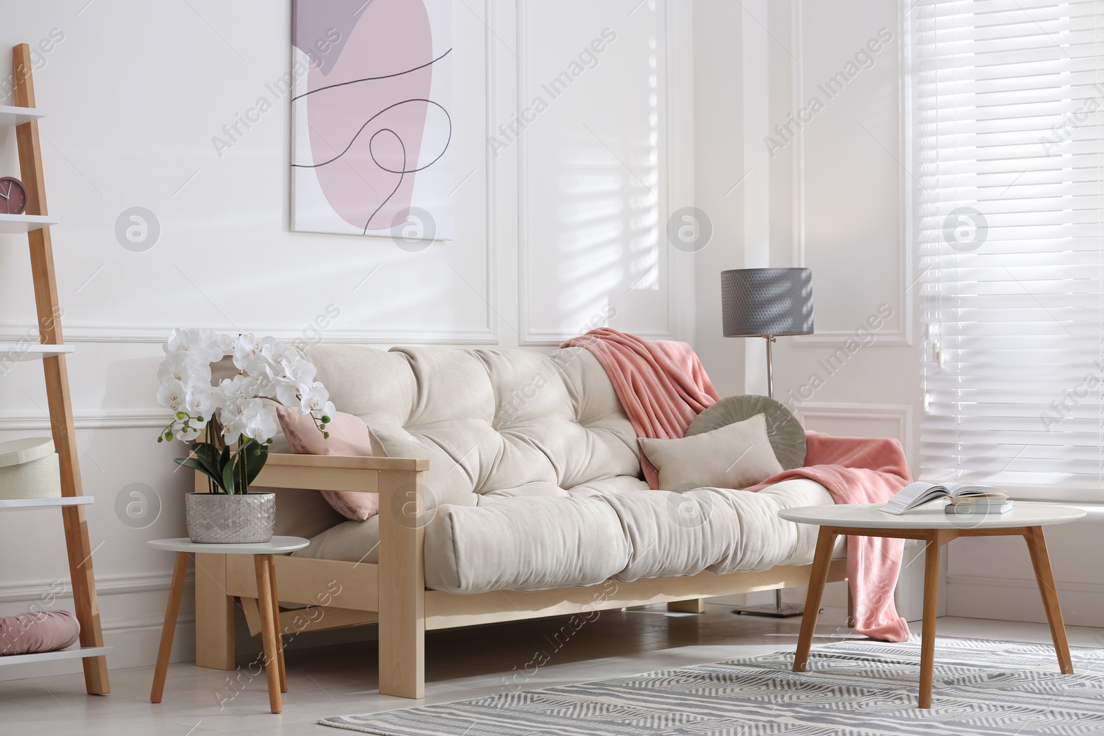 Photo of Stylish living room interior with comfortable sofa and beautiful orchid flower