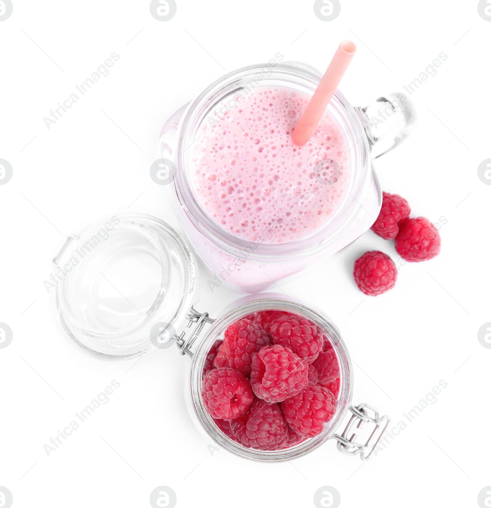 Photo of Tasty raspberry milk shake in mason jar and fresh berries isolated on white, top view