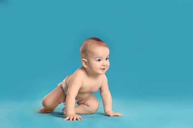 Photo of Cute little baby in diaper on light blue background