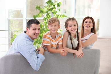 Photo of Happy family with cute children on sofa at home