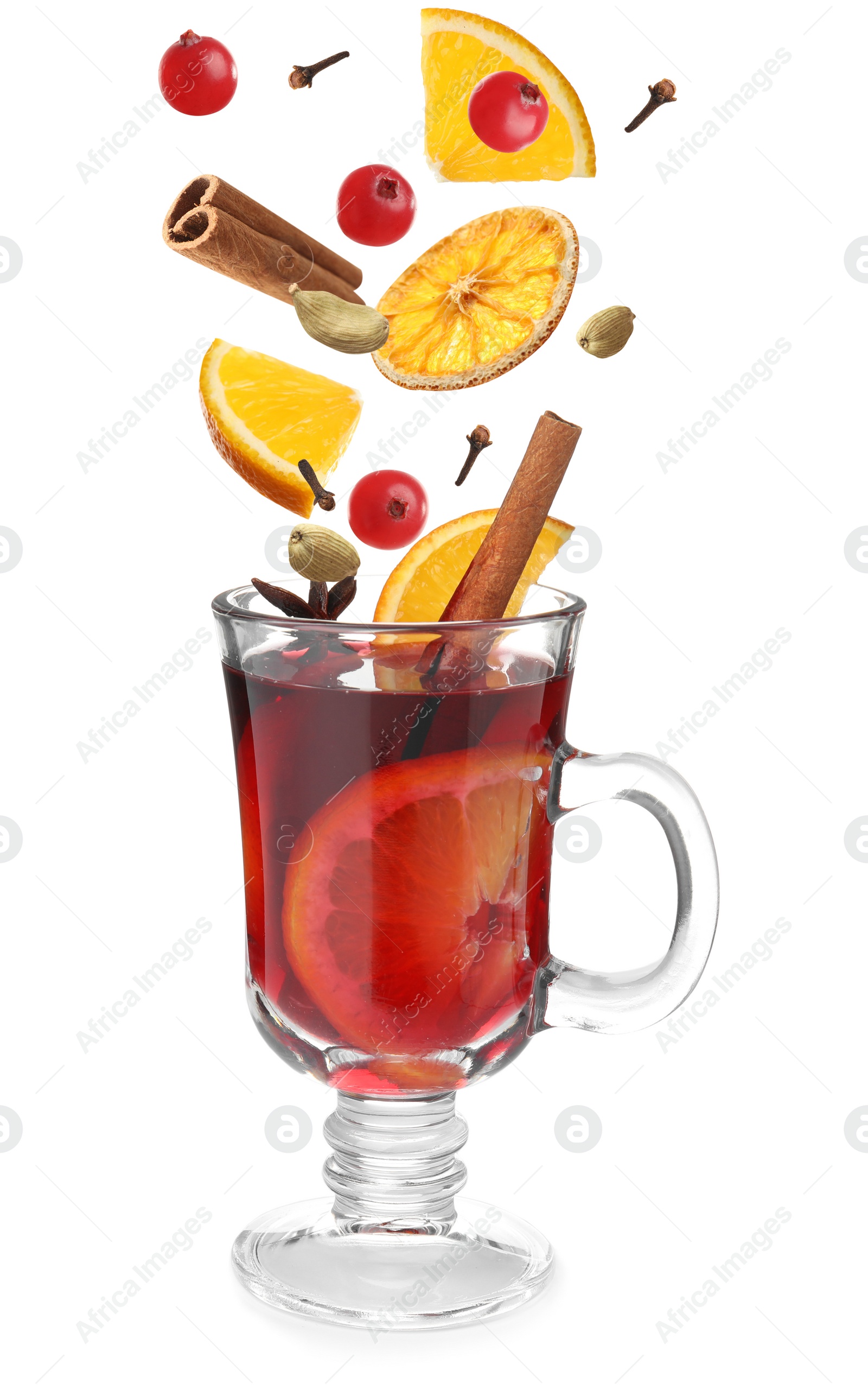 Image of Cut orange, cranberries and different spices falling into glass cup of mulled wine on white background 