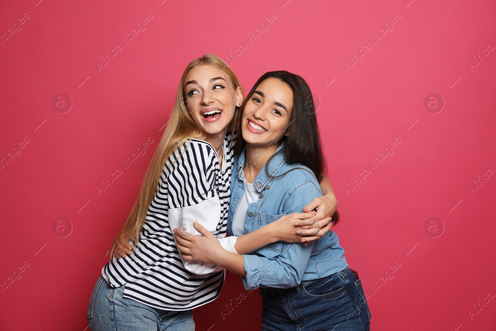 Photo of Young women laughing together against color background