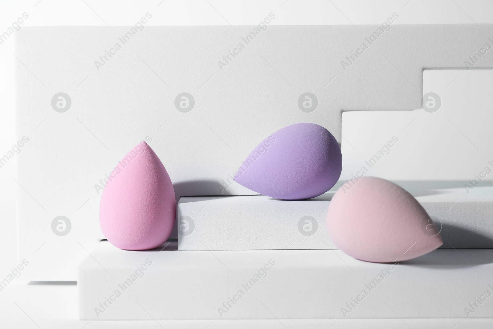 Photo of Stylish presentation of makeup sponges on white background