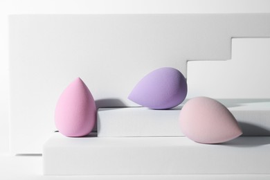 Stylish presentation of makeup sponges on white background