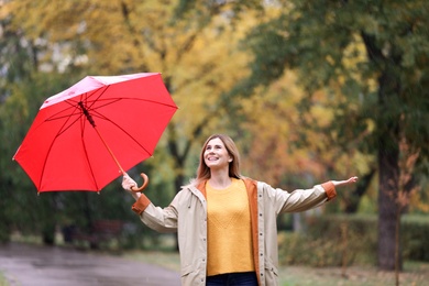 Photo of Woman with umbrella in autumn park on rainy day