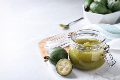 Feijoa jam and fresh fruits on white table. Space for text