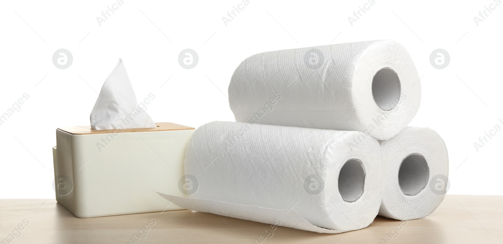 Photo of Rolls and box of clean paper tissues on wooden table