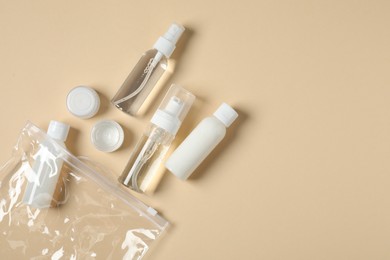 Photo of Cosmetic travel kit and plastic bag on beige background, flat lay with space for text. Bath accessories