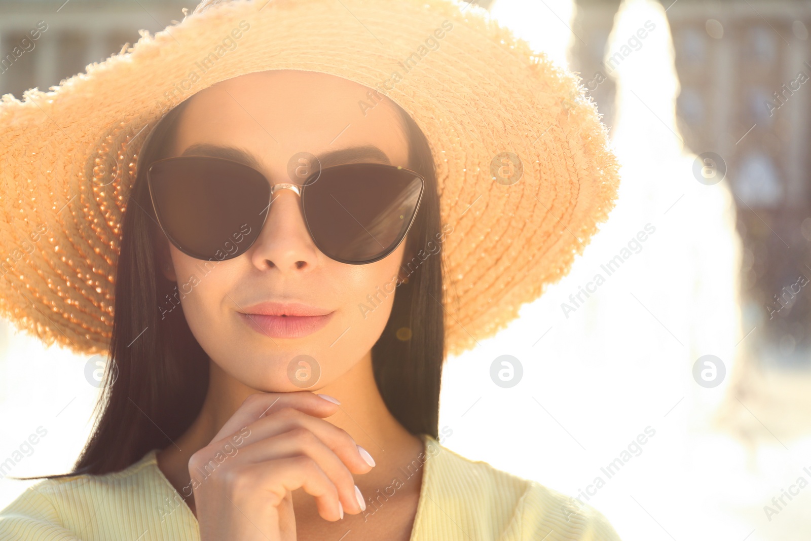 Photo of Beautiful young woman wearing stylish sunglasses outdoors, closeup