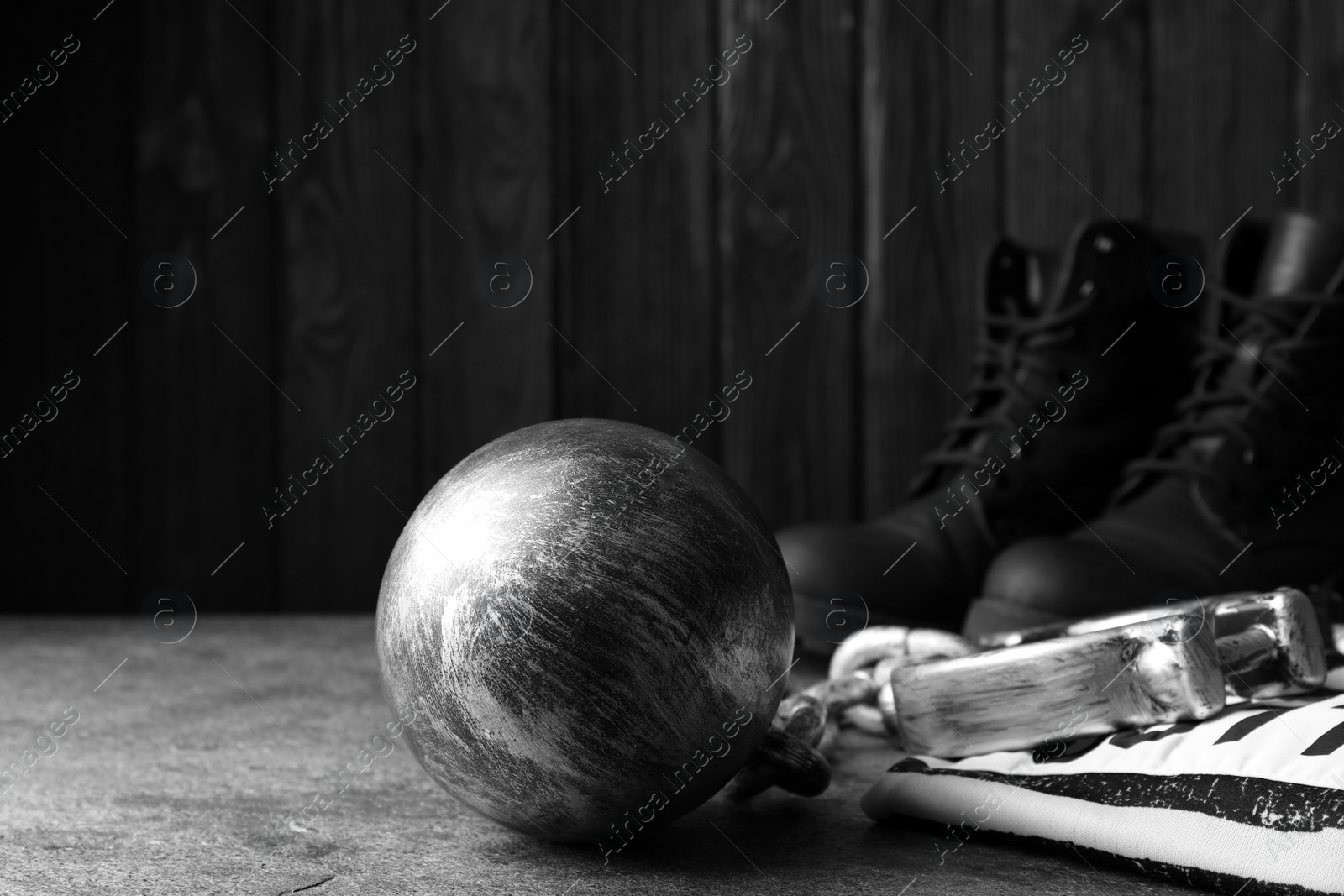 Photo of Prisoner ball with chain, jail clothes and boots on grey table