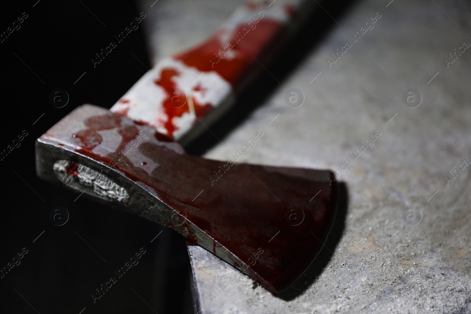 Photo of Axe with blood on old metal surface, closeup