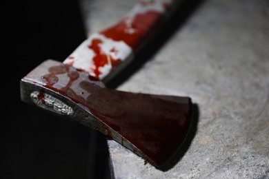 Axe with blood on old metal surface, closeup