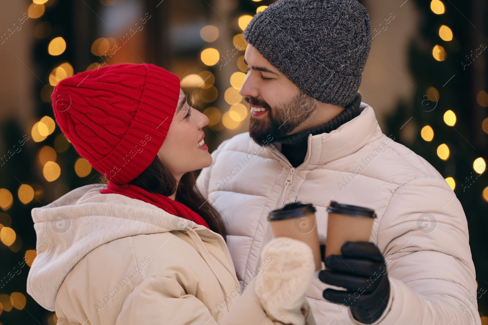 Photo of Lovely couple with hot drinks spending time together outdoors
