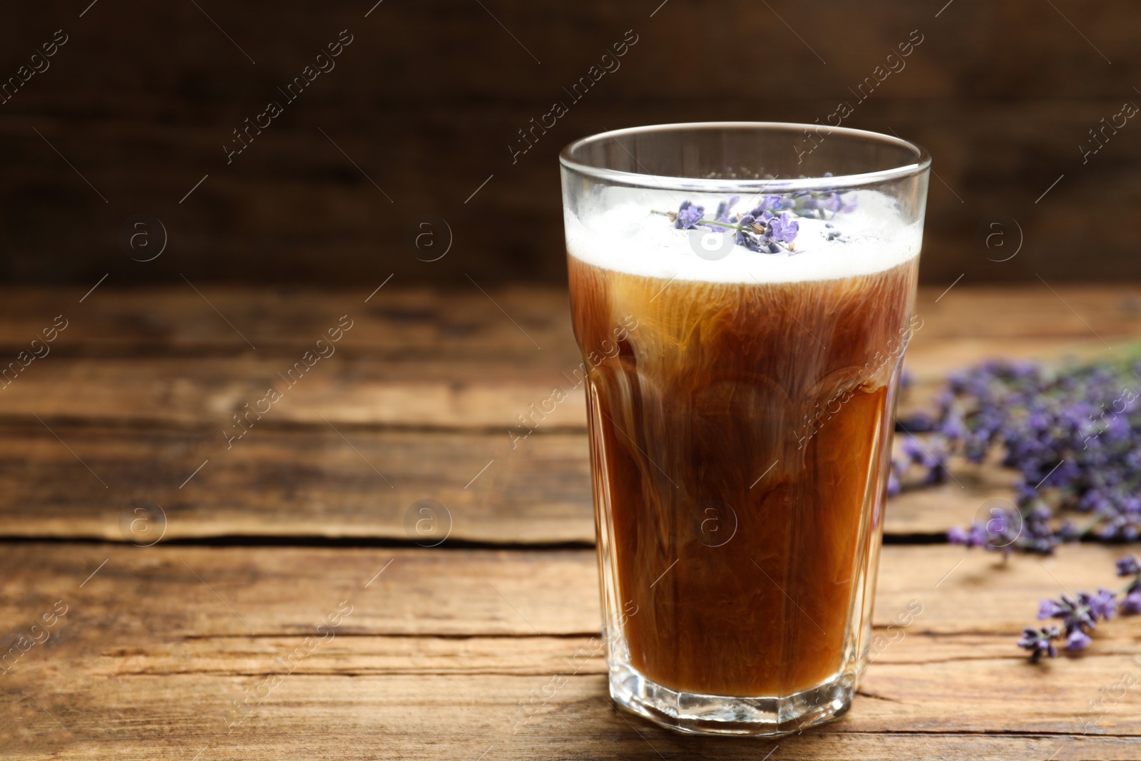 Photo of Delicious coffee with lavender on wooden table. Space for text